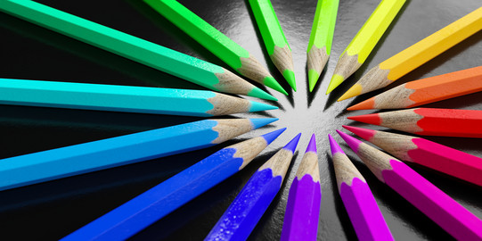 Buntstifte gemäß Farbverlauf im Kreis angeordnet, die Spitzen zeigen nach innen