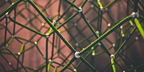 Netzwerk aus dünnen grünen Seilen mit Knotenpunkten aus Metall 