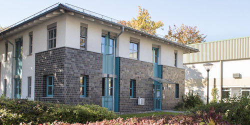 Baroper Straße 283 - Zweistöckiges Gebäude mit grau-weißer Fassade und türkisen Fensterrahmen