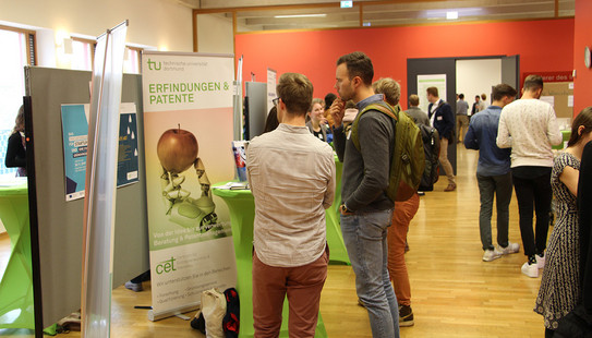 DocDay Mehrere Personen vor verschiedenen Roll-ups beim Eröffnungstag des Graduiertenzentrums in 2019