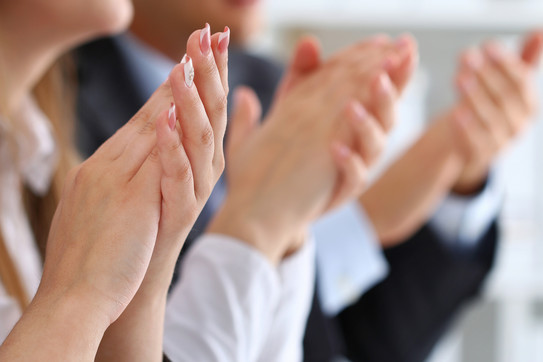 Several hands of women and men clap.