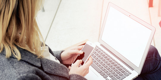 A woman has a laptop on her lap